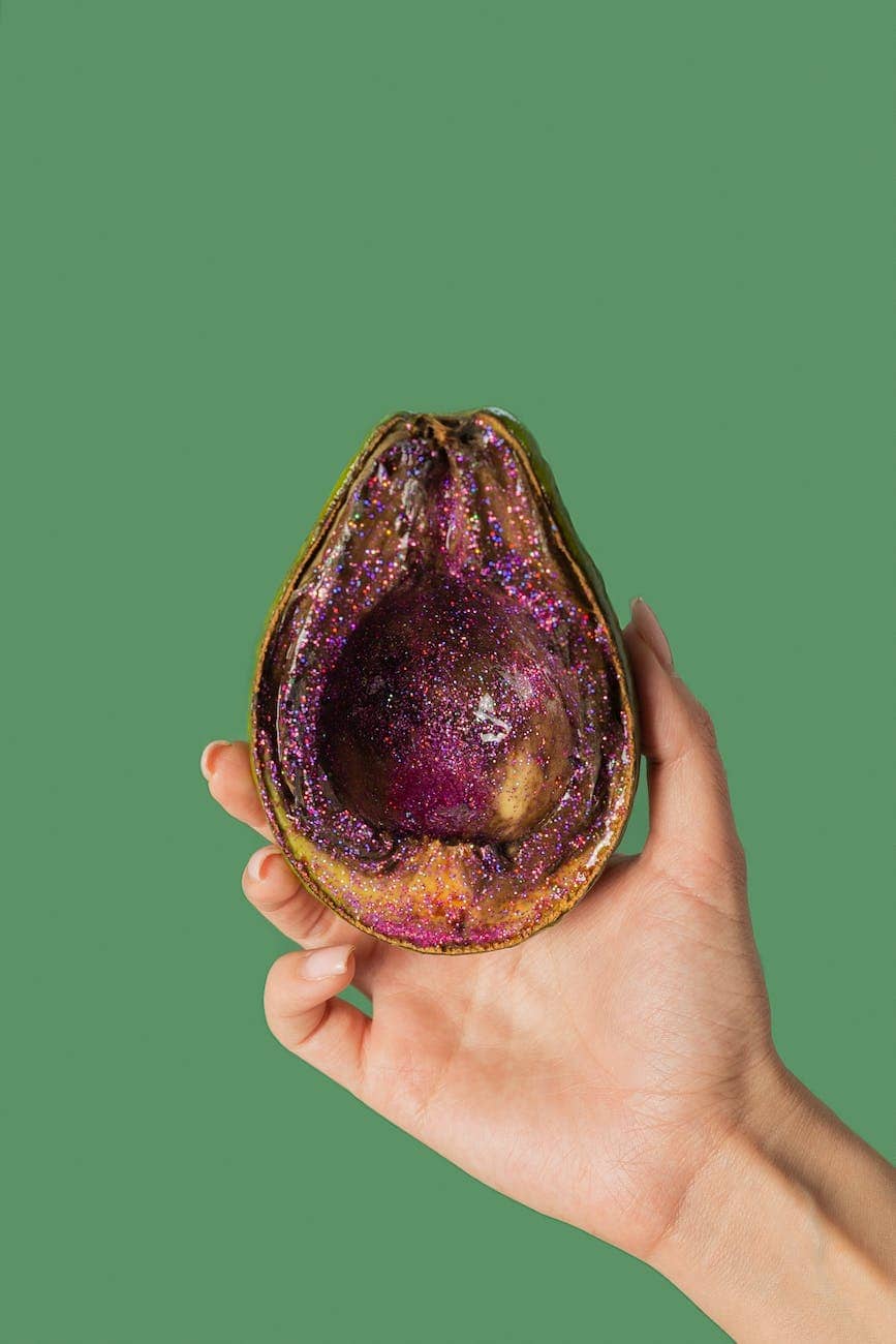 female showing half avocado with pink glitter